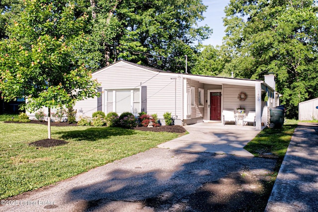 3400 Dell Rd, Louisville, KY 40299 - view of front of house featuring concrete driveway, a front lawn, a carport, and a chimney