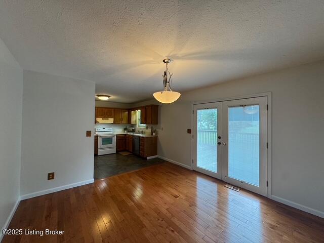 45 Paula Ct, Ekron, KY 40117 - unfurnished living room featuring dark wood-style flooring, baseboards, french doors, and a textured ceiling