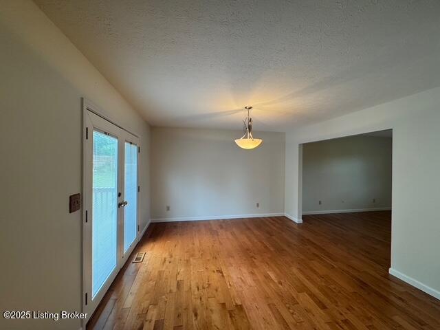 45 Paula Ct, Ekron, KY 40117 - spare room with wood finished floors, a textured ceiling, and baseboards
