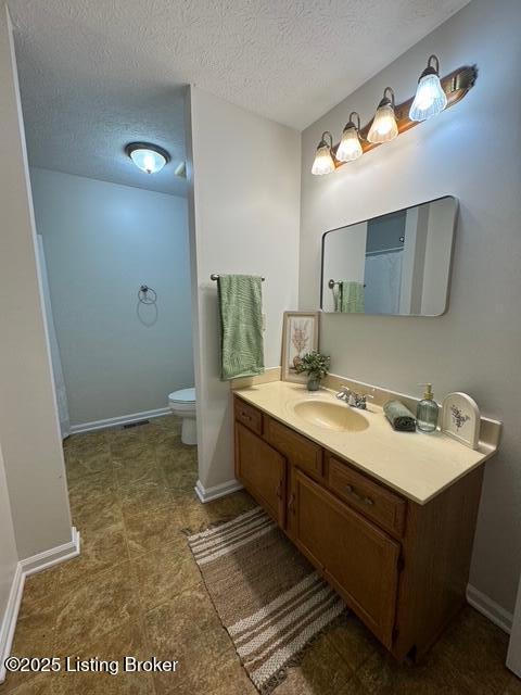 45 Paula Ct, Ekron, KY 40117 - bathroom featuring toilet, vanity, a textured ceiling, and baseboards