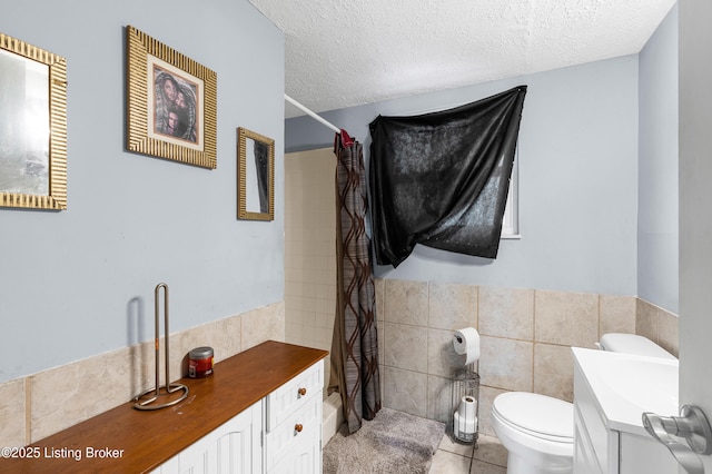 533 Wyandot Ct, Radcliff, KY 40160 - full bath featuring tile patterned floors, vanity, tile walls, toilet, and a textured ceiling