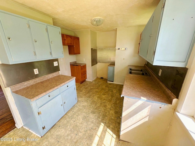 515 Gumwell Rd, Brandenburg, KY 40108 - kitchen with a sink, a textured ceiling, light floors, light countertops, and baseboards