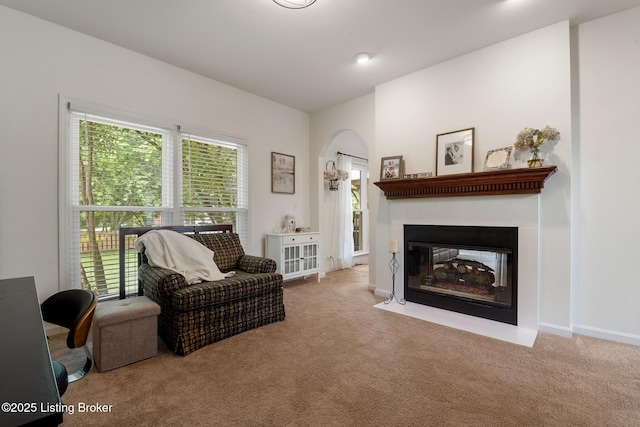 13512 Springs Station Rd, Louisville, KY 40245 - carpeted living room featuring arched walkways, a fireplace with flush hearth, and baseboards