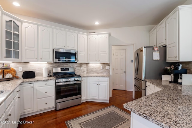 13512 Springs Station Rd, Louisville, KY 40245 - kitchen featuring appliances with stainless steel finishes, white cabinetry, dark wood-type flooring, backsplash, and glass insert cabinets