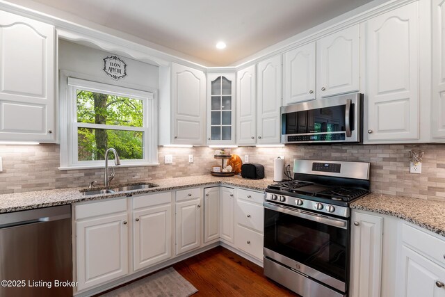 13512 Springs Station Rd, Louisville, KY 40245 - kitchen featuring appliances with stainless steel finishes, a sink, white cabinetry, tasteful backsplash, and dark wood-type flooring