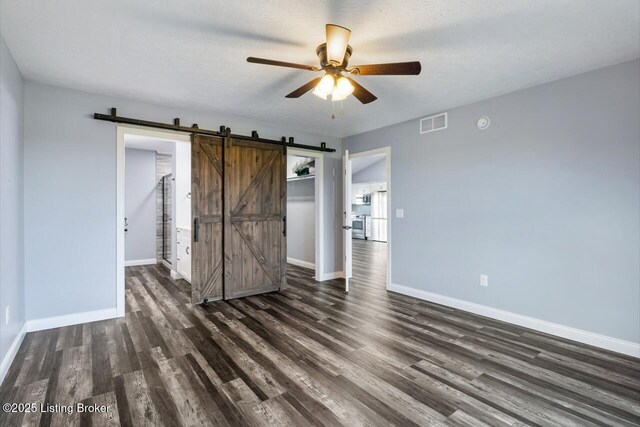 760 Leafdale Rd, Hodgenville, KY 42748 - unfurnished bedroom featuring a barn door, wood finished floors, baseboards, a closet, and a ceiling fan