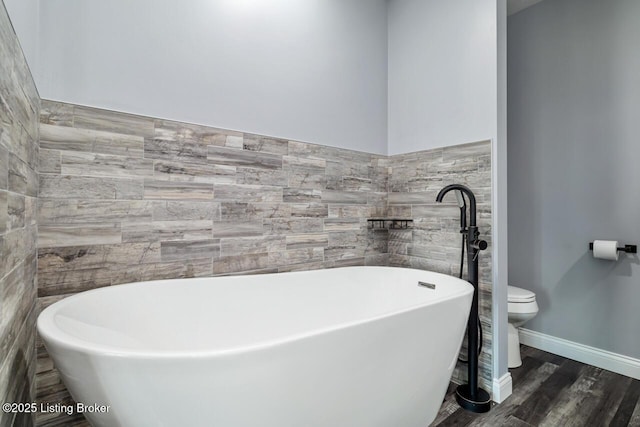 760 Leafdale Rd, Hodgenville, KY 42748 - full bathroom featuring toilet, tile walls, wood finished floors, and a soaking tub