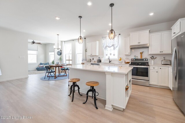 816 Snead Ct, Simpsonville, KY 40067 - kitchen with appliances with stainless steel finishes, under cabinet range hood, a sink, a center island, and decorative backsplash