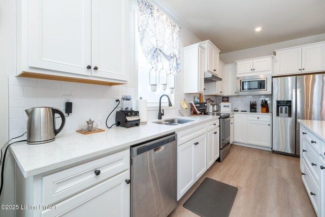 816 Snead Ct, Simpsonville, KY 40067 - kitchen featuring appliances with stainless steel finishes, a sink, white cabinets, decorative backsplash, and light wood-style flooring
