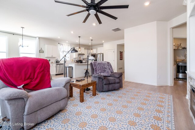 816 Snead Ct, Simpsonville, KY 40067 - living room with ceiling fan, light wood-style floors, recessed lighting, baseboards, and a chandelier