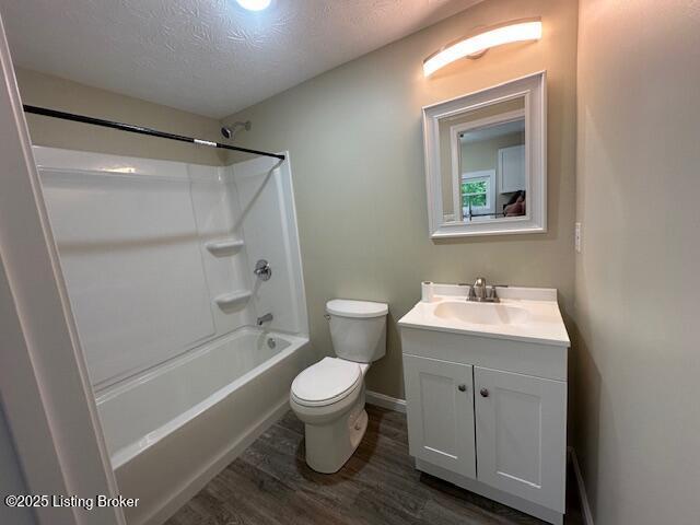 4515 Wolf Creek Rd, Battletown, KY 40104 - bathroom with wood finished floors, a textured ceiling, toilet, vanity, and baseboards