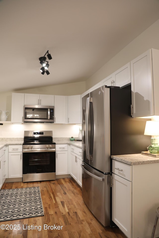 456 E Brandeis Ave, Louisville, KY 40217 - kitchen featuring appliances with stainless steel finishes, white cabinetry, light wood-style floors, and light stone counters
