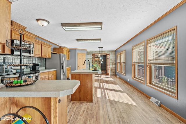 1210 Christian Church Rd, Brandenburg, KY 40108 - kitchen with stainless steel fridge, light wood-type flooring, a sink, light countertops, and ornamental molding