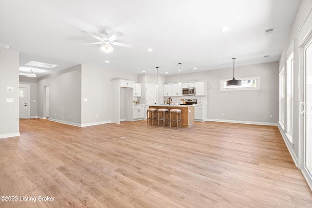 801 Artisan Pkwy, La Grange, KY 40031 - unfurnished living room with recessed lighting, baseboards, a ceiling fan, light wood-style flooring, and a sink