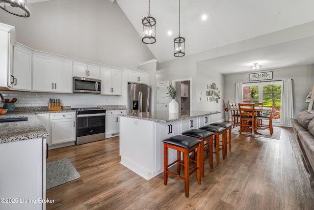458 Christman Ln, Shepherdsville, KY 40165 - kitchen featuring stainless steel appliances, high vaulted ceiling, a center island, a chandelier, and white cabinetry