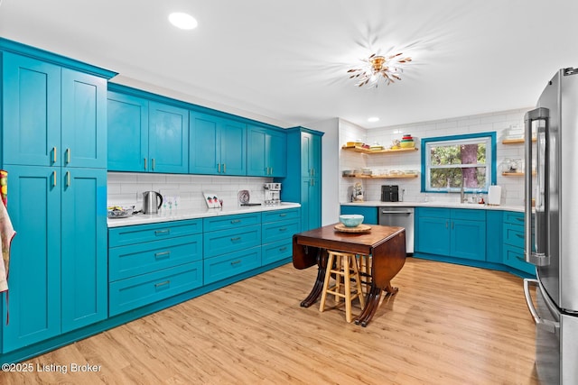 607 Edgemont Rd, Irvington, KY 40146 - kitchen with stainless steel appliances, decorative backsplash, light wood-style floors, light countertops, and open shelves