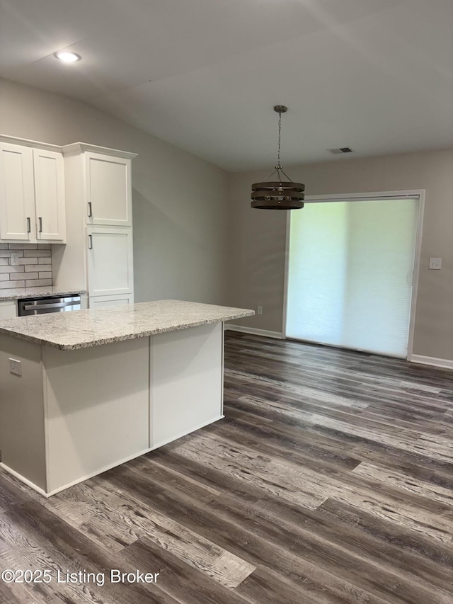 7997 Pikewood Field Way, Louisville, KY 40219 - kitchen with dark wood finished floors, white cabinetry, light stone countertops, backsplash, and hanging light fixtures