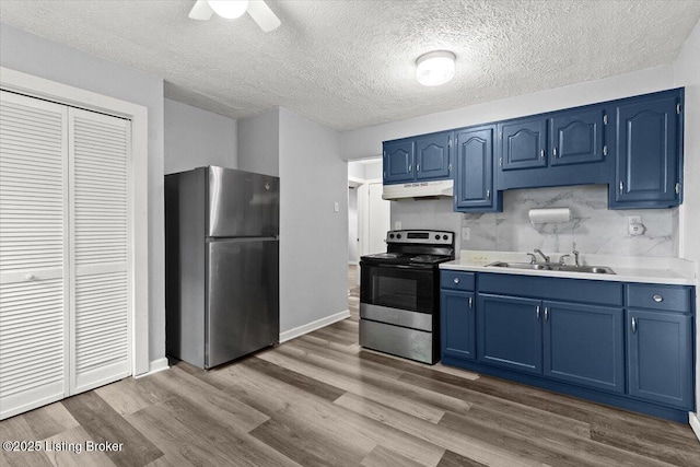 404 Diecks Dr, Elizabethtown, KY 42701 - kitchen with appliances with stainless steel finishes, blue cabinets, under cabinet range hood, a sink, and wood finished floors