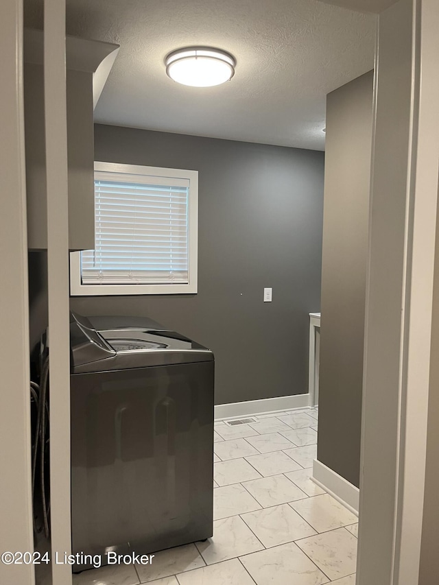 107 Clymene Rd, Cecilia, KY 42724 - washroom featuring light marble finish floors, baseboards, a textured ceiling, and washing machine and dryer