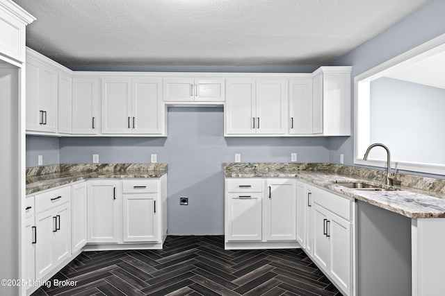 113 Mckay Ave, Bloomfield, KY 40008 - kitchen featuring a sink, light stone countertops, white cabinetry, and a textured ceiling