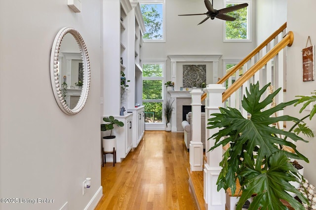 13318 Stepping Stone Way, Louisville, KY 40299 - entryway featuring ceiling fan, light wood-style flooring, a tiled fireplace, stairway, and a towering ceiling