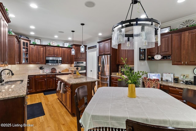 13318 Stepping Stone Way, Louisville, KY 40299 - kitchen featuring appliances with stainless steel finishes, a sink, ornamental molding, a center island, and light wood finished floors