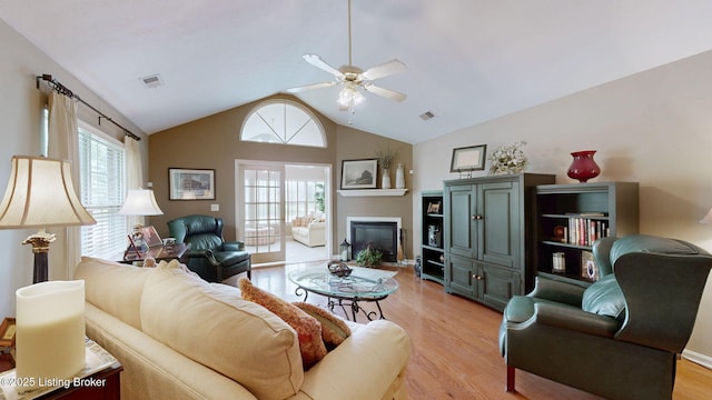 10409 Pine Glen Cir, Louisville, KY 40291 - living area with a ceiling fan, light wood-style flooring, vaulted ceiling, and a glass covered fireplace