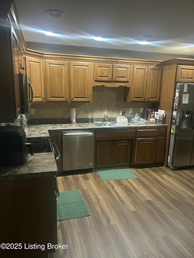 105B Twin Oaks Dr, Bardstown, KY 40004 - kitchen featuring appliances with stainless steel finishes, a sink, light wood-style floors, brown cabinets, and dark countertops