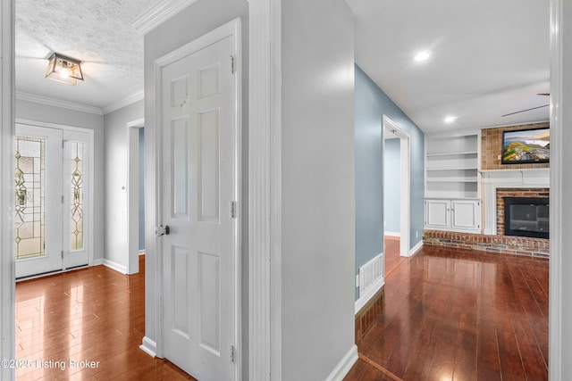 1312 Pollitt Ct, Louisville, KY 40223 - foyer entrance with hardwood / wood-style flooring, baseboards, a fireplace, ornamental molding, and a textured ceiling