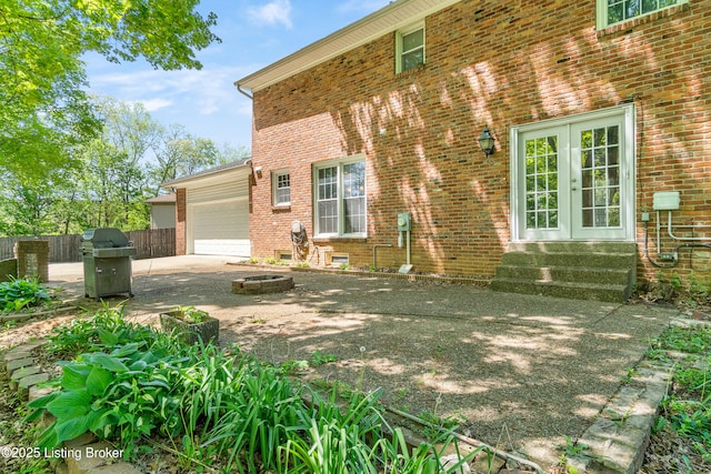 1312 Pollitt Ct, Louisville, KY 40223 - entrance to property featuring a garage, brick siding, french doors, and driveway