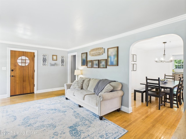 4932 Southern Pkwy, Louisville, KY 40214 - living room featuring arched walkways, a chandelier, light wood-type flooring, crown molding, and baseboards