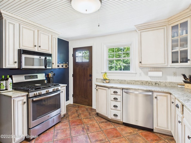 4932 Southern Pkwy, Louisville, KY 40214 - kitchen with stainless steel appliances, tile patterned flooring, cream cabinets, glass insert cabinets, and light stone countertops