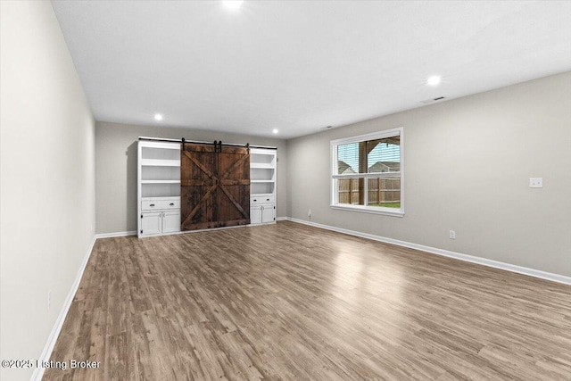 102 Limestone Ct, Shepherdsville, KY 40165 - unfurnished living room with a barn door, wood finished floors, baseboards, and recessed lighting