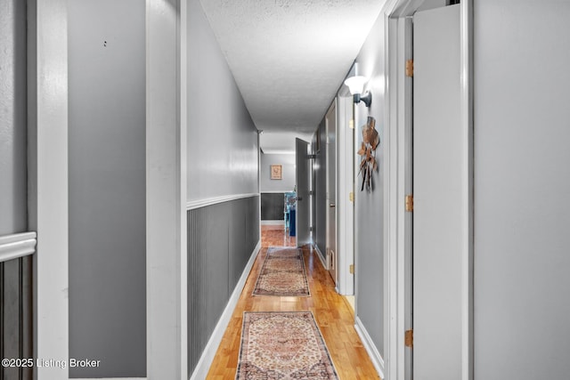 94 Tarnwood Dr, Brandenburg, KY 40108 - corridor featuring light wood finished floors, a textured ceiling, and baseboards