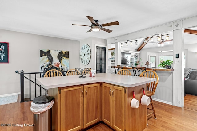 94 Tarnwood Dr, Brandenburg, KY 40108 - kitchen with a ceiling fan, a breakfast bar area, light countertops, and light wood-style flooring