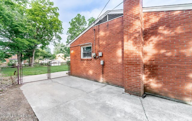 1057 Hillview Blvd, Shepherdsville, KY 40229 - view of side of property with a gate, brick siding, and a chimney