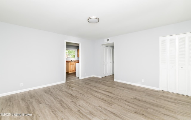 1057 Hillview Blvd, Shepherdsville, KY 40229 - unfurnished bedroom featuring two closets, wood finished floors, baseboards, and connected bathroom