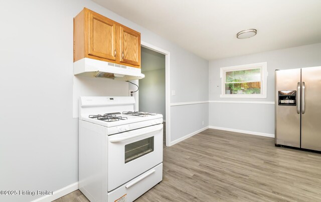 1057 Hillview Blvd, Shepherdsville, KY 40229 - kitchen featuring stainless steel fridge, white gas stove, under cabinet range hood, light wood finished floors, and baseboards
