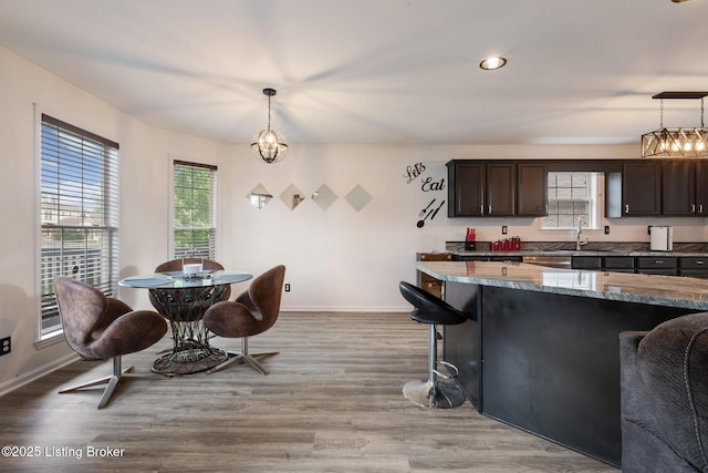 6820 Grandfield Rd, Louisville, KY 40258 - kitchen featuring healthy amount of natural light, dark brown cabinetry, a kitchen breakfast bar, stone counters, and recessed lighting