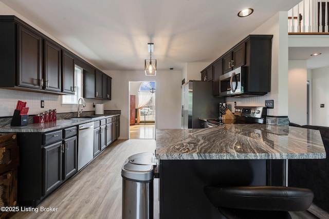 6820 Grandfield Rd, Louisville, KY 40258 - kitchen featuring appliances with stainless steel finishes, a sink, light wood finished floors, and backsplash