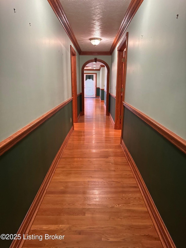 5309 Bardstown Rd, Springfield, KY 40069 - hallway with arched walkways, ornamental molding, a textured ceiling, and light wood finished floors