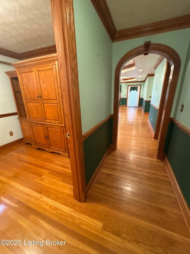5309 Bardstown Rd, Springfield, KY 40069 - corridor with ornamental molding, arched walkways, light wood-style floors, and a textured ceiling