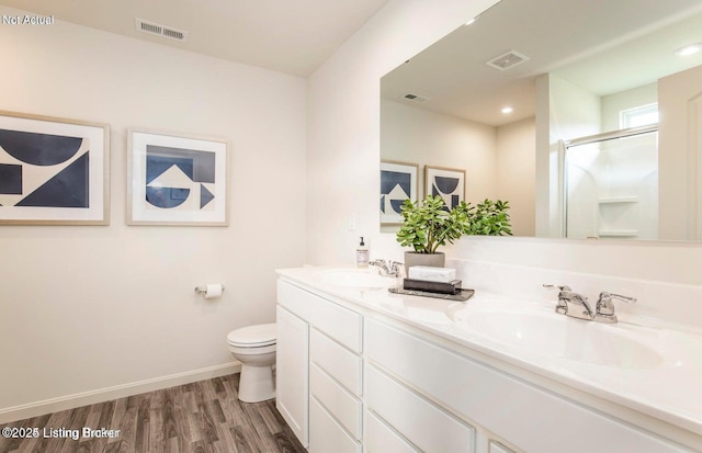 1853 Washington Blvd, Lyndon, KY 40242 - bathroom with double vanity, toilet, wood finished floors, an enclosed shower, and baseboards
