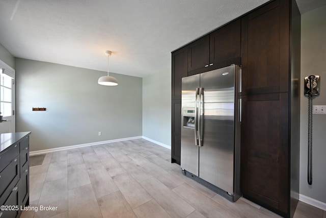 7514 Pimlico Dr, Louisville, KY 40214 - kitchen with stainless steel fridge, dark brown cabinetry, hanging light fixtures, and baseboards