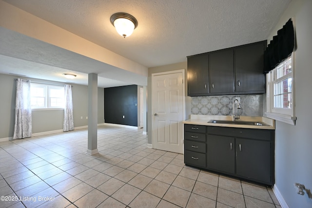 7514 Pimlico Dr, Louisville, KY 40214 - kitchen with a sink, a textured ceiling, light countertops, light tile patterned flooring, and decorative backsplash