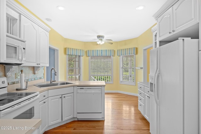 966 Lawrence St, Brandenburg, KY 40108 - kitchen with white appliances, a sink, a peninsula, a ceiling fan, and light wood finished floors