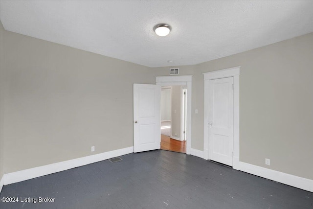 621 S 41st St, Louisville, KY 40211 - unfurnished bedroom featuring baseboards, dark wood-type flooring, a textured ceiling, and a closet