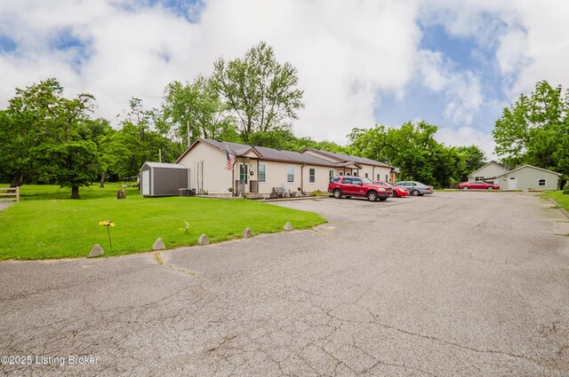 912 Cedar St, New Albany, IN 47150 - view of front facade with a storage unit, uncovered parking, and a front yard