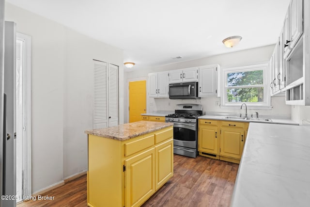823 S Jackson St, Louisville, KY 40203 - kitchen with black microwave, gas range, a sink, dark wood-style flooring, and a center island