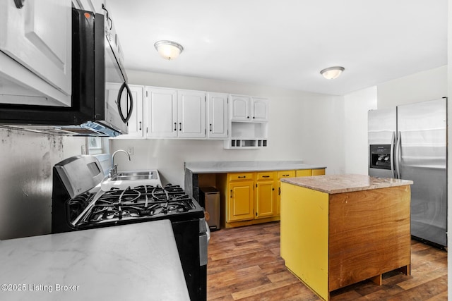 823 S Jackson St, Louisville, KY 40203 - kitchen featuring appliances with stainless steel finishes, a sink, a kitchen island, wood finished floors, and light countertops